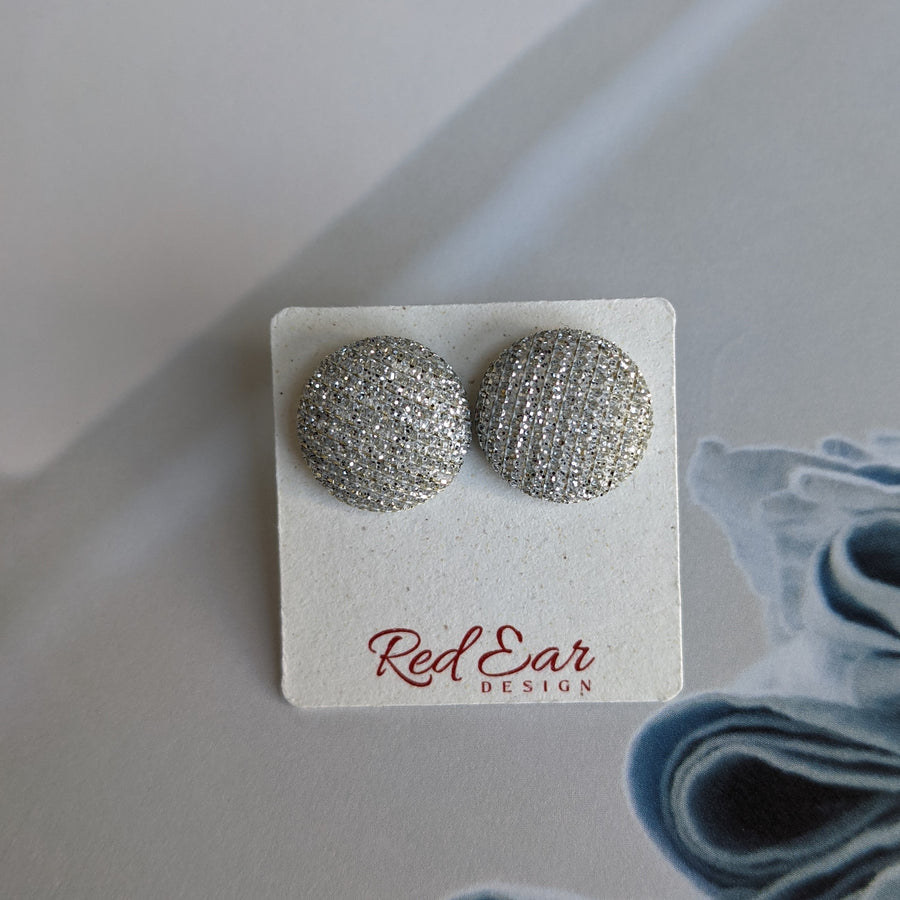 Srebrni uhani na kartončku blagovne znamke RedEar Design.